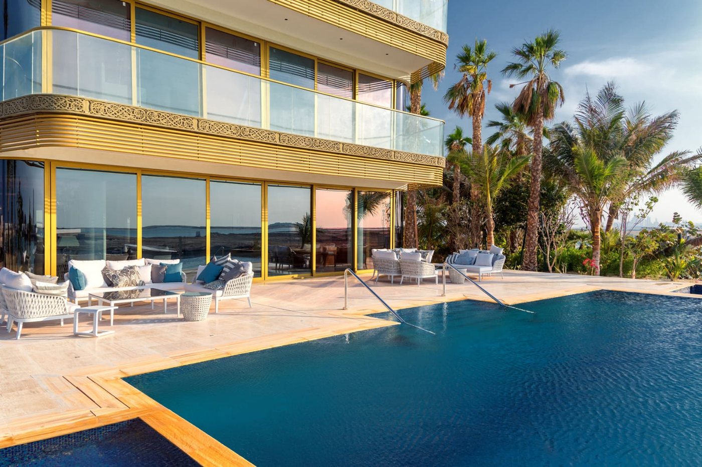Villa on The World Islands Dubai with gold-framed sliding glazing beside an infinity pool